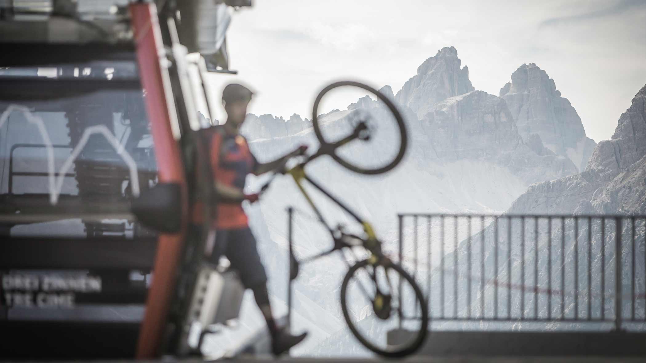 Mann steigt mit dem Mountainbike aus der Gondel im Skigebiet Helm - Hotel Simpaty